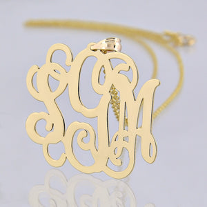 1.25-inch custom solid gold monogram pendant without a chain on a clean background.