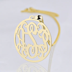 Close-up of a 10k or 14k solid gold three-initial circle monogram pendant with a gold chain