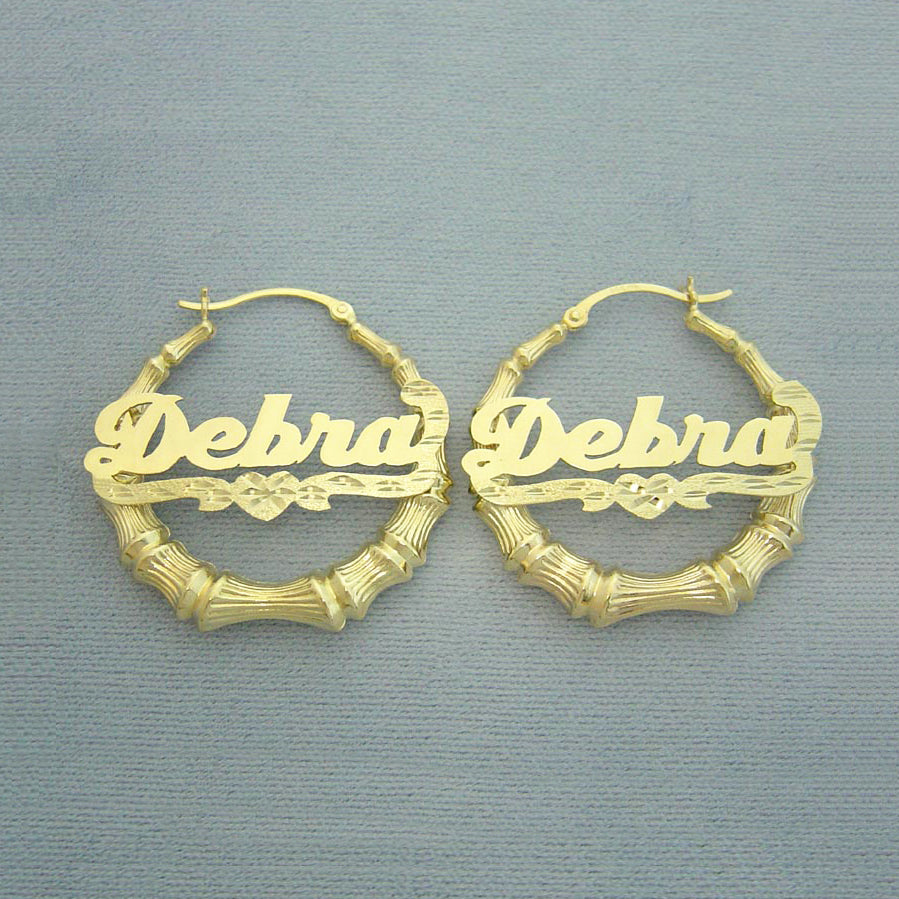 Solid 10k or 14k gold personalized bamboo hoop earrings featuring cursive name lettering and diamond cut heart accent
