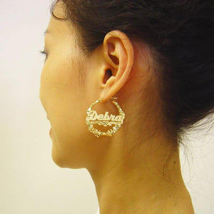 Model wearing custom 1.3-inch solid gold bamboo hoop earrings with personalized cursive name plate