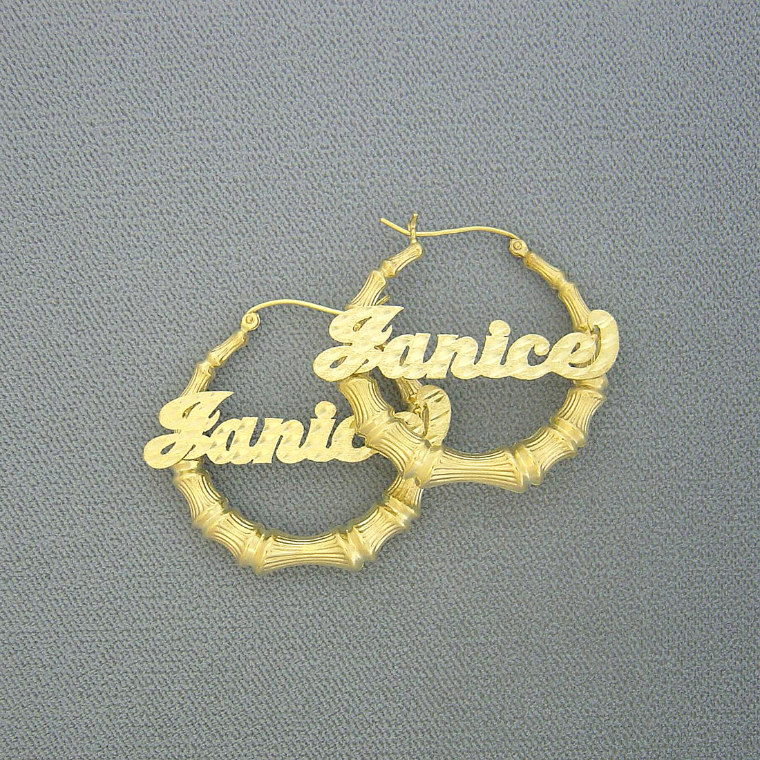Pair of 10K/14K solid gold bamboo hoop earrings featuring personalized diamond-cut script name Janice