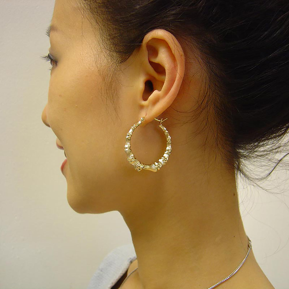 1 3/8 inch gold bamboo hoop earrings on the model