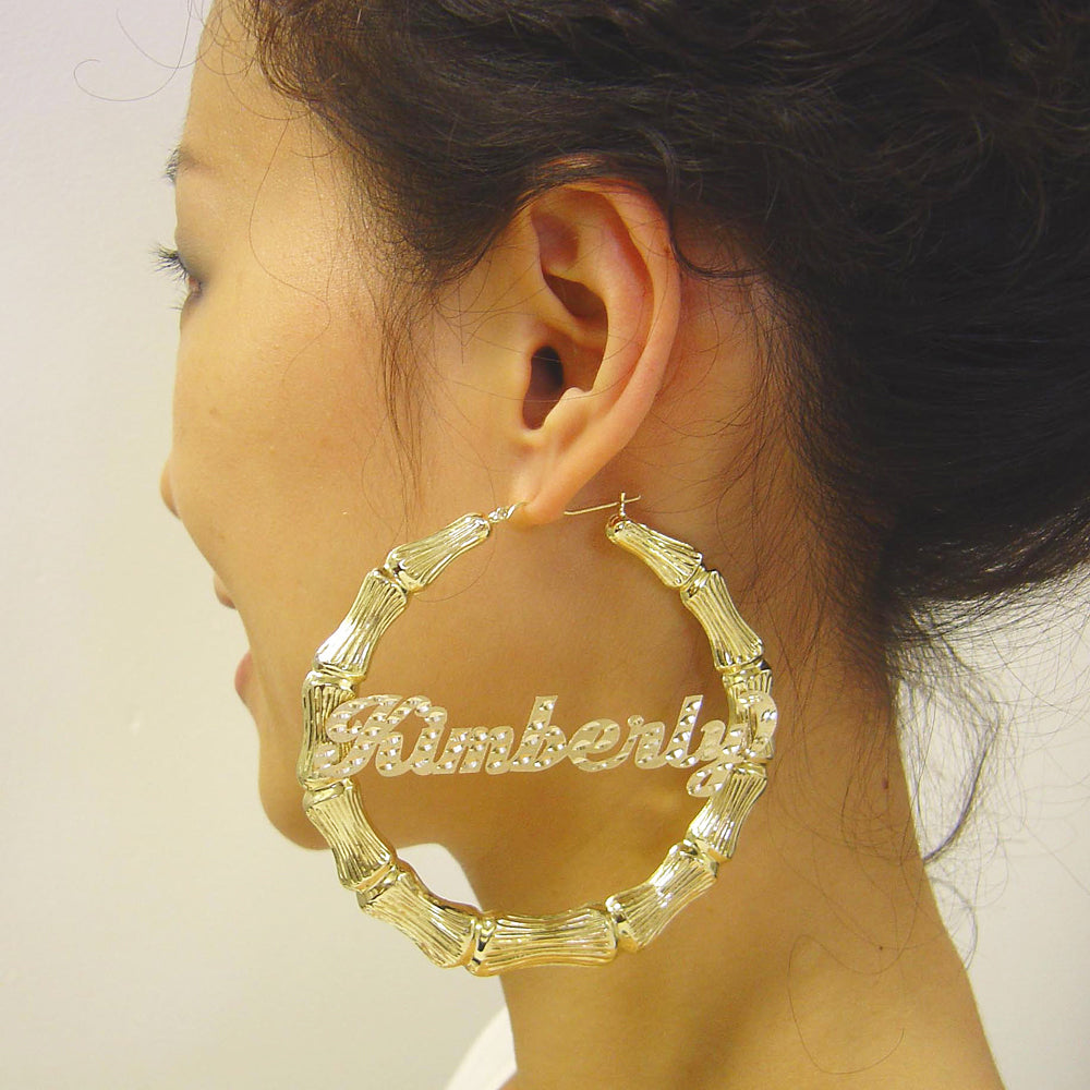 Model wearing 3.4 inch extra large 10K gold personalized bamboo name hoop earrings