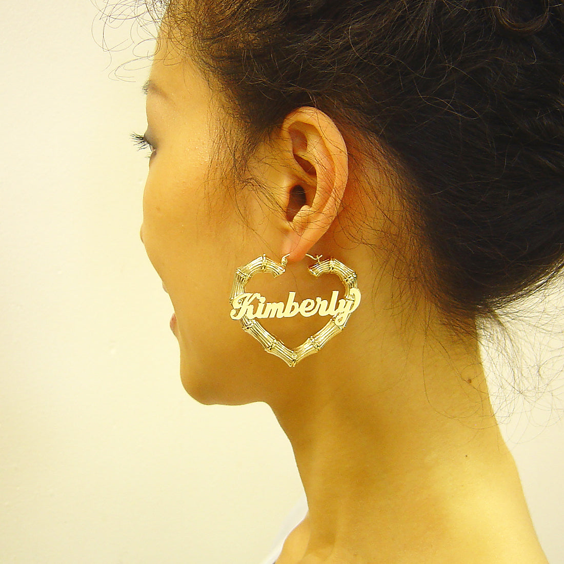 Close-up detail of personalized nameplate on 2 inch gold heart bamboo hoop earrings