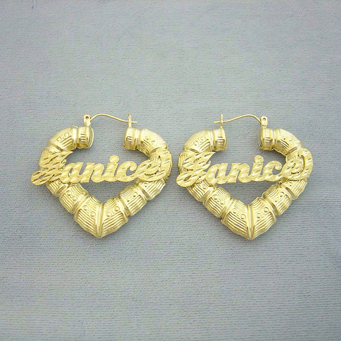 Pair of 10K yellow gold personalized puffy heart bamboo name earrings with custom diamond-cut cursive lettering