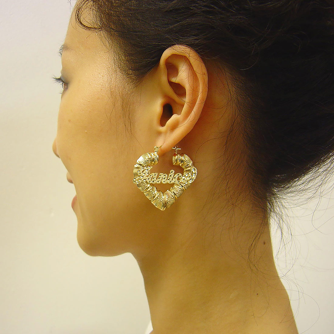 1.5 inch 10K gold personalized puffy heart bamboo name hoop earrings shown for size scale
