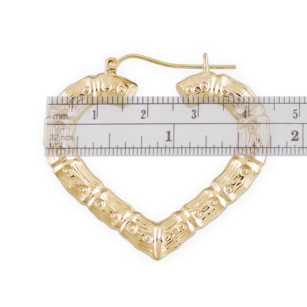 Close-up view of 10K yellow gold heart bamboo hoop earring showing hollow puffed texture and latch closure.