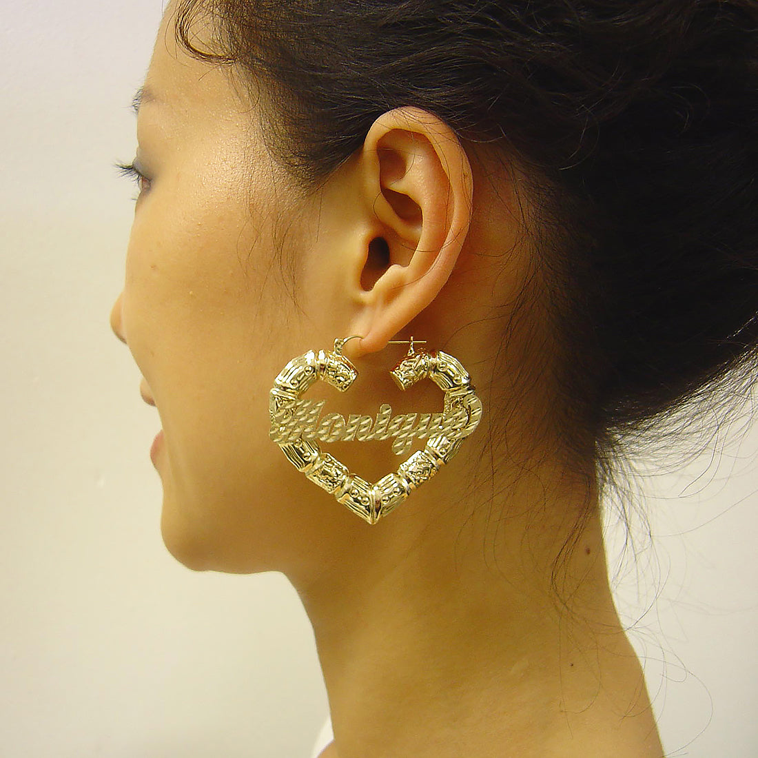 Model wearing 2.18-inch 10k gold personalized puffy heart bamboo hoop earrings