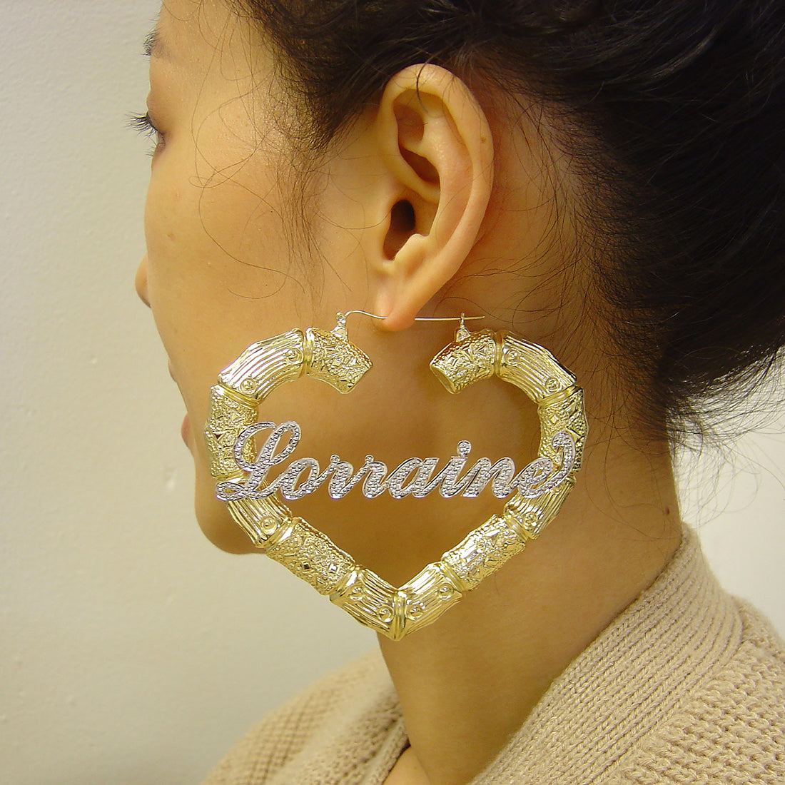 Close-up of personalized 10K gold cursive name script on 3.5 inch heart-shaped bamboo hoop earrings