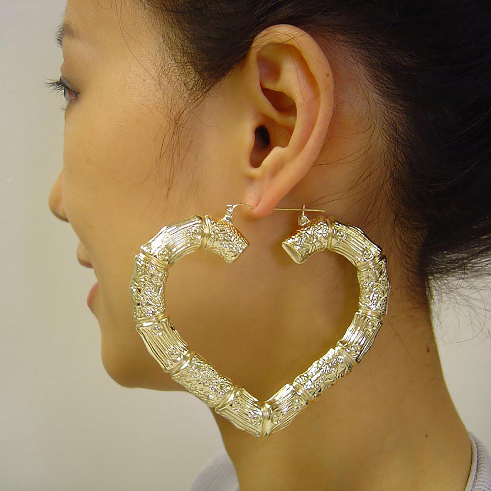 Model wearing 3.5-inch oversized 10K real gold puffed heart bamboo door knocker hoops