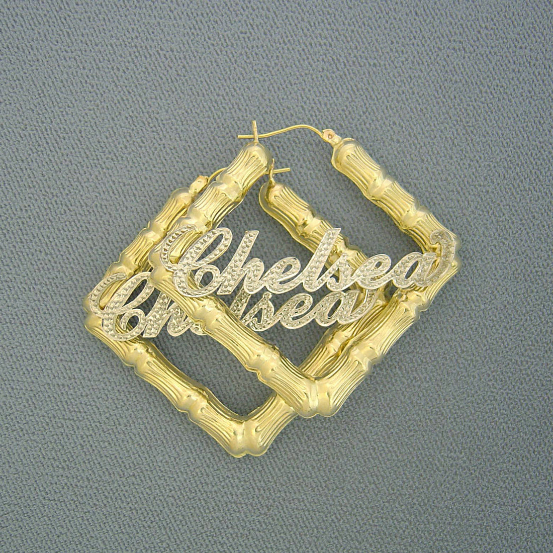 Close-up of customized iced-out cursive nameplate on 10K two-tone gold hoop earring