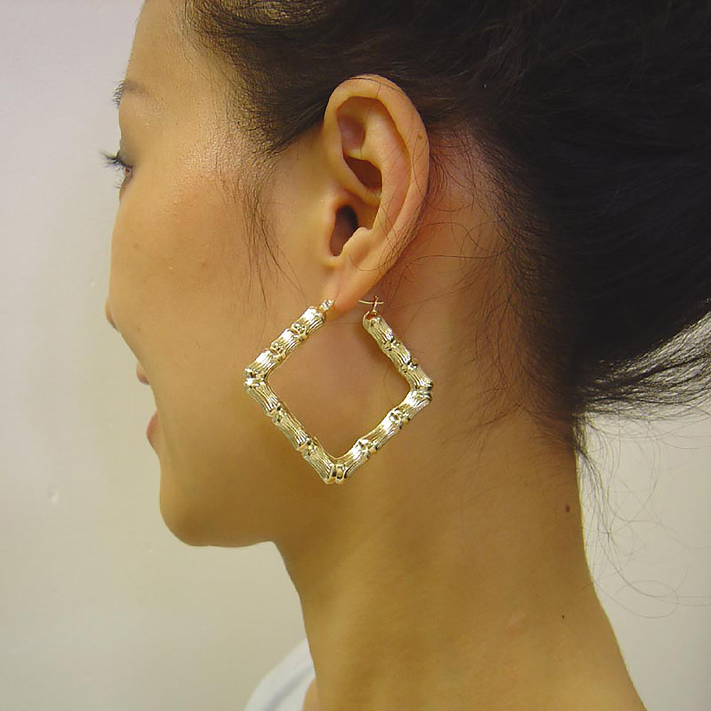 Model wearing 2 inch 10K gold square puffed bamboo door knocker hoop earrings