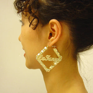 Side view of 2.5-inch 10K solid gold square bamboo name hoop earring worn