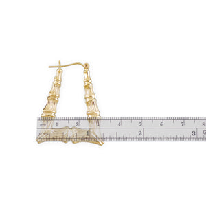 Ruler measuring 1.25 inch width and 1.5 inch height of 10K gold rectangular bamboo hoop earrings.