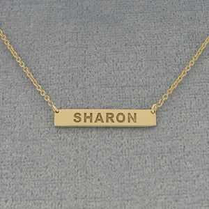 Close-up of 7/8 inch extra small white gold horizontal nameplate bar necklace with high-contrast laser engraving