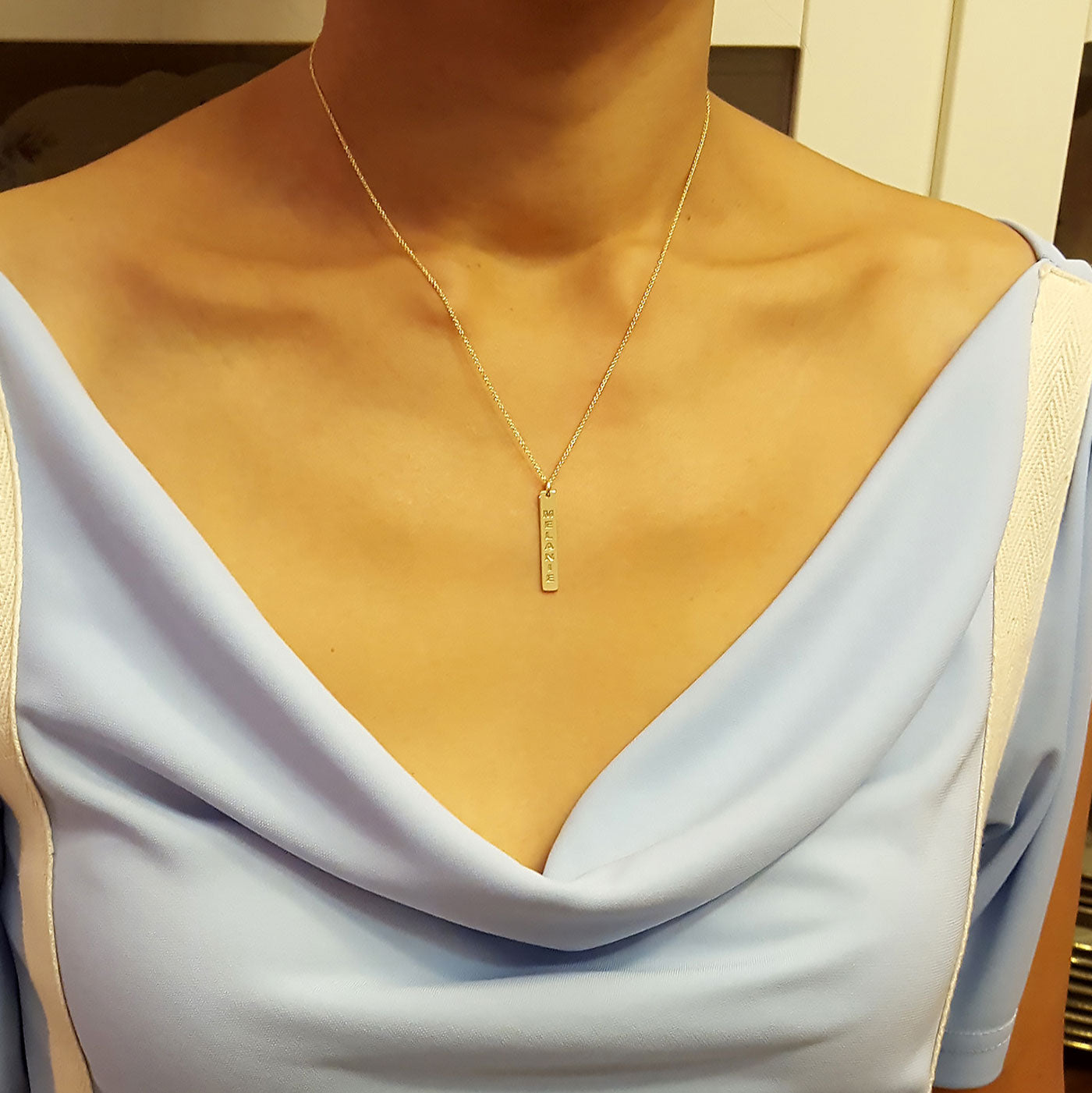 Dainty solid gold personalized vertical bar necklace worn on model