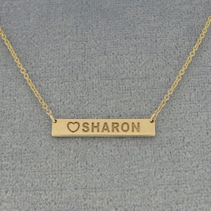 Close-up of solid gold personalized heart name bar pendant
