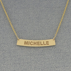 Close up of custom laser engraved solid gold horizontal curve bar pendant