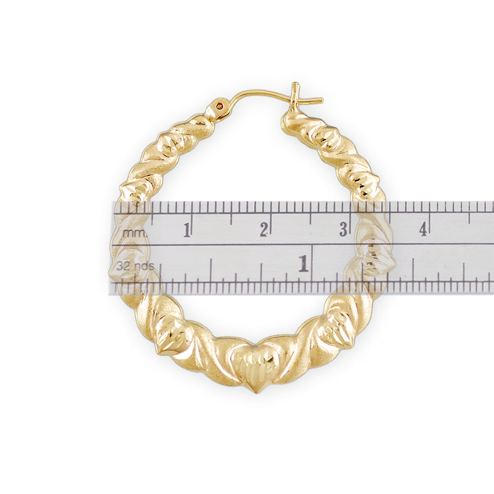 Close-up of 10K gold puffed XO hoop earring showing diamond cut finish and snap hinge lock