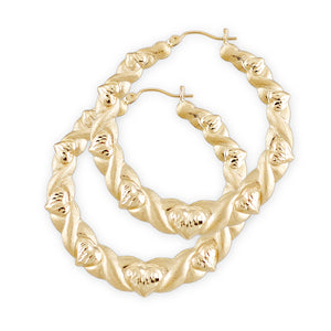 A pair of 10k gold hollow hoop earrings with a diamond cut pattern designed to resemble kisses and hugs, inspired by 80s fashion.