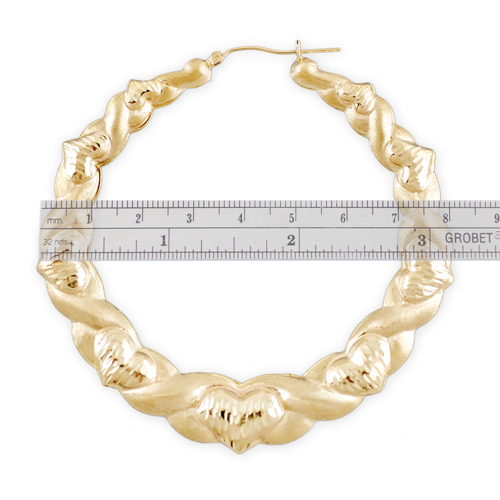 Close-up of diamond-cut heart accents and XO pattern on 10K yellow gold earrings