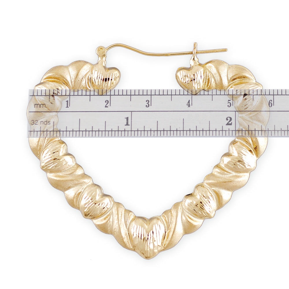 Side view of 10K yellow gold hollow XO heart hoop earrings with snap closure