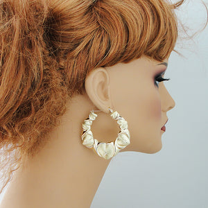 Mannequin wearing 2.1 inch 10K gold XO puffy heart doorknocker earrings