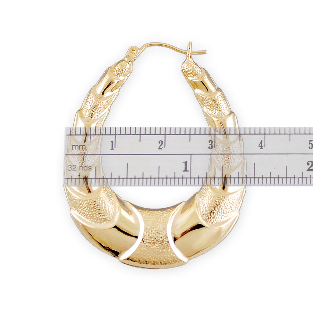 Textured 10K yellow gold puffed shrimp door knocker earring detail with snap closure