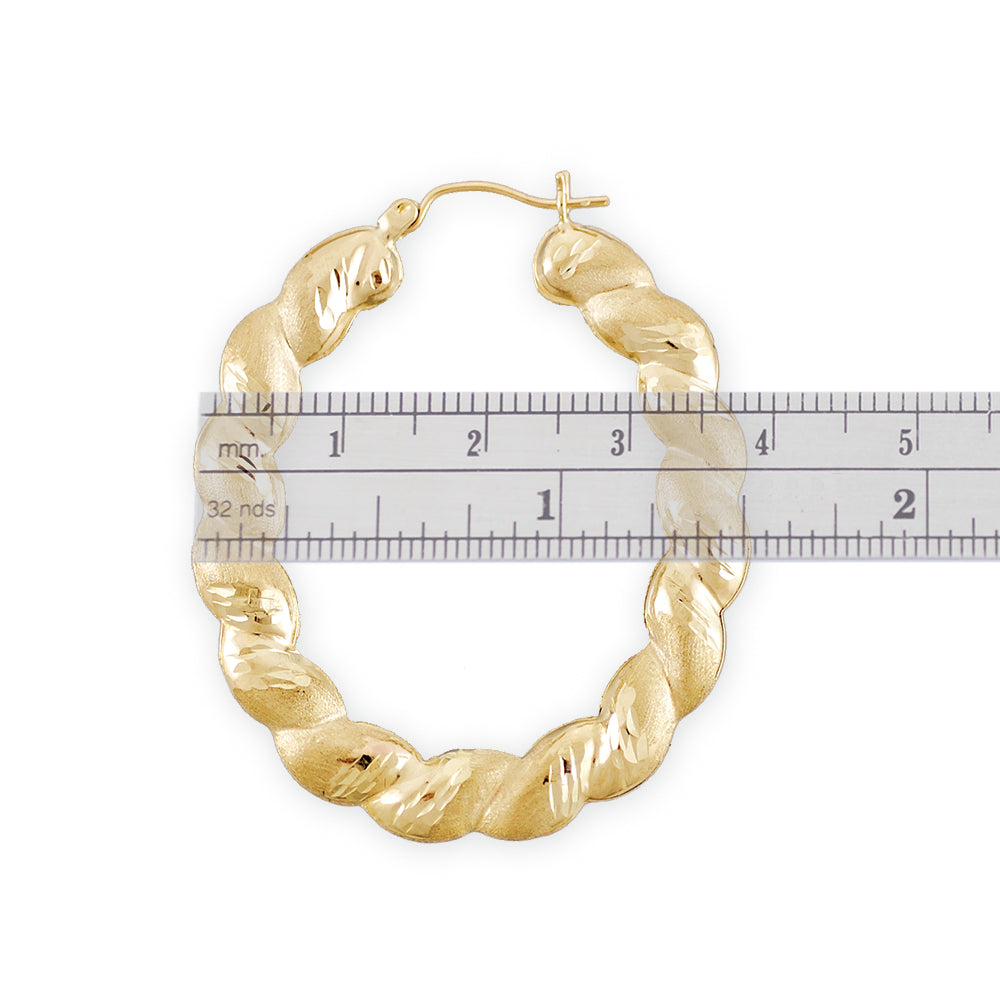 Close-up of diamond-cut texture on 10K solid gold oval hoop earring