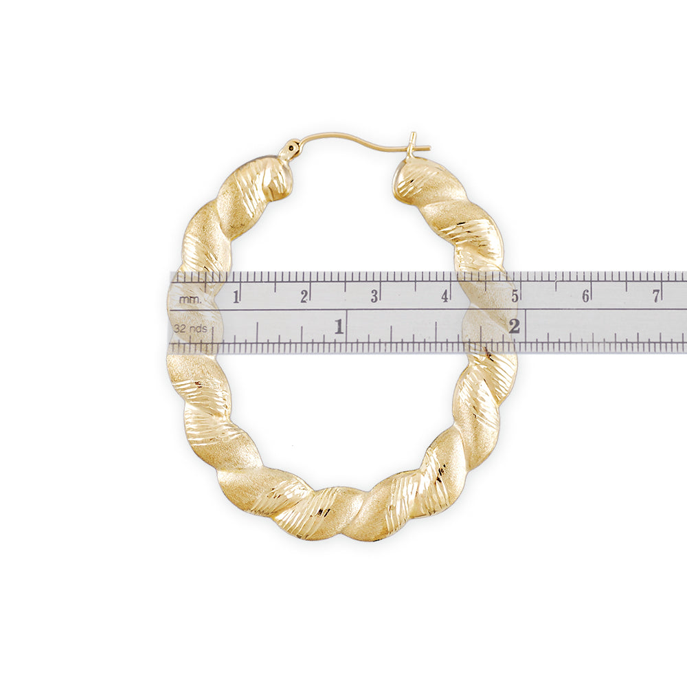 Close-up detail of 10K gold twisted diamond-cut pattern on oval door knocker earring