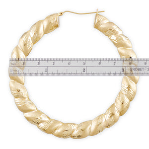 Close-up of diamond-cut texture and hinged snap-bar closure on 10K gold twisted door knocker earring