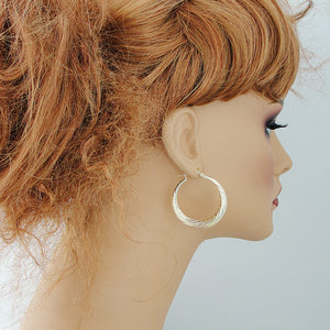Side view of 1.5 inch 10K real gold swirl door knocker hoop earrings