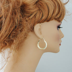 wearing 10K solid gold 1.25 inch puffy door knocker drop earrings