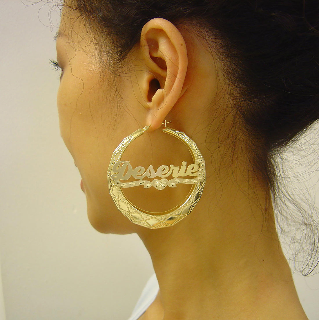 Model wearing 2.25 inch 10K gold personalized round doorknocker name hoop earrings