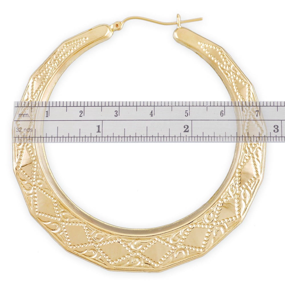 10K yellow gold patterned doorknocker hoop earrings shown next to a ruler measuring 2.9 inches in diameter