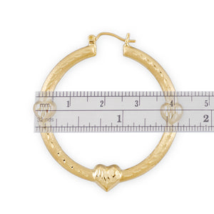 Detailed view of 10K gold diamond-cut layered puffy heart doorknocker earrings