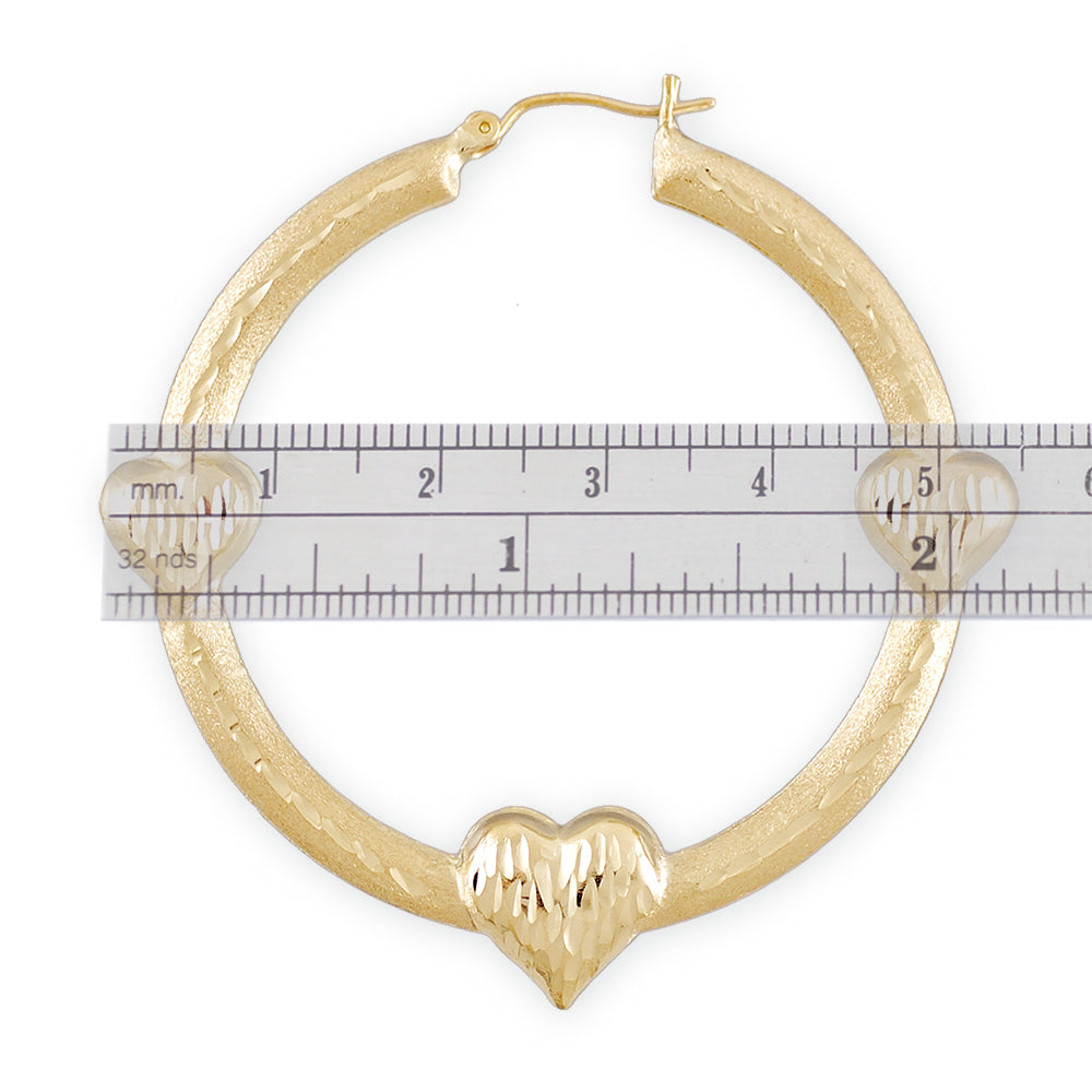 Close-up of diamond-cut details on 10K gold 3-heart doorknocker earrings