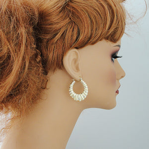 wearing 10K gold diamond-cut puffy shrimp hoop earrings showing size and fit