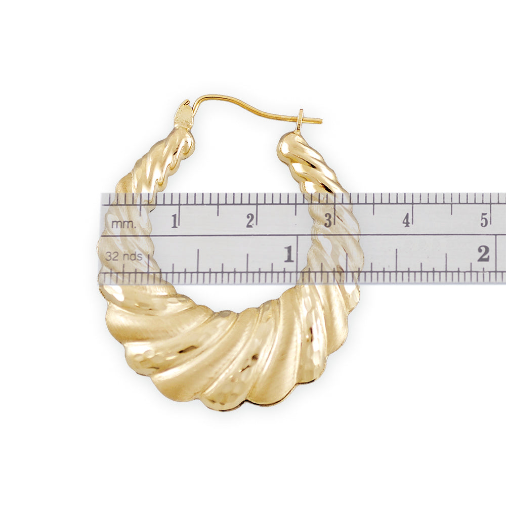 Close-up of diamond-cut swirl pattern and secure clip closure on 10K gold door knocker earring