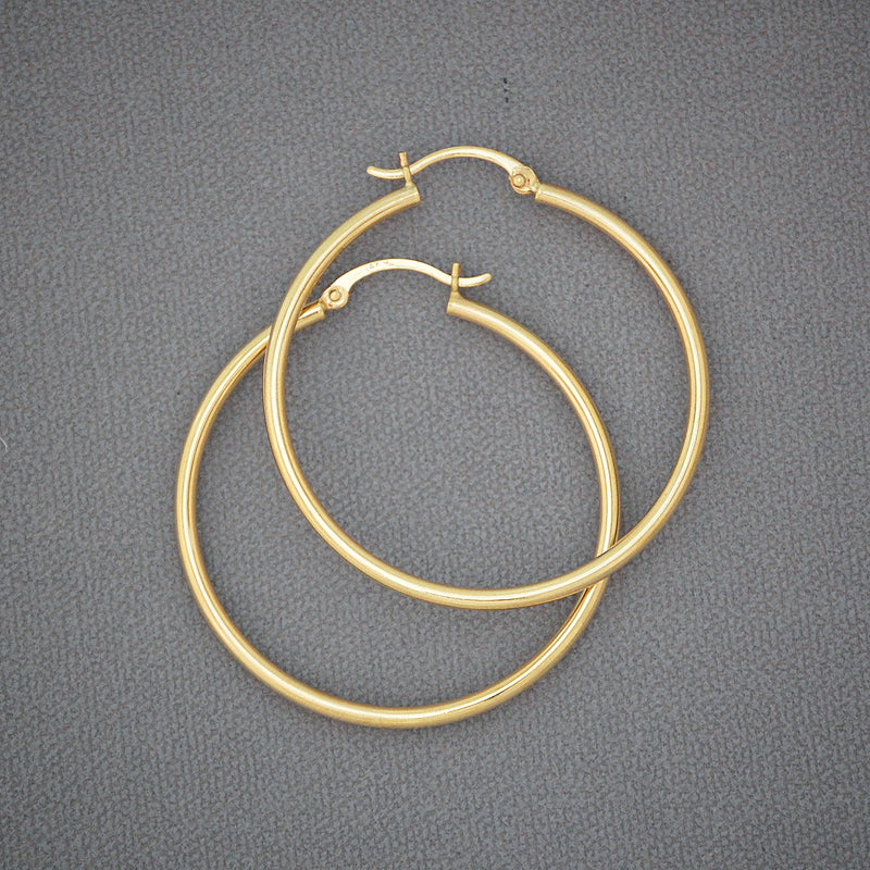 Pair of 14K yellow gold 1.5-inch round hoop earrings with a 2mm hollow tube design