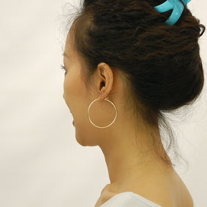 Model wearing 1.75 inch 14K yellow gold 2mm hollow plain hoop earrings
