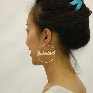 Model wearing custom 14k yellow gold personalized name hoop earrings