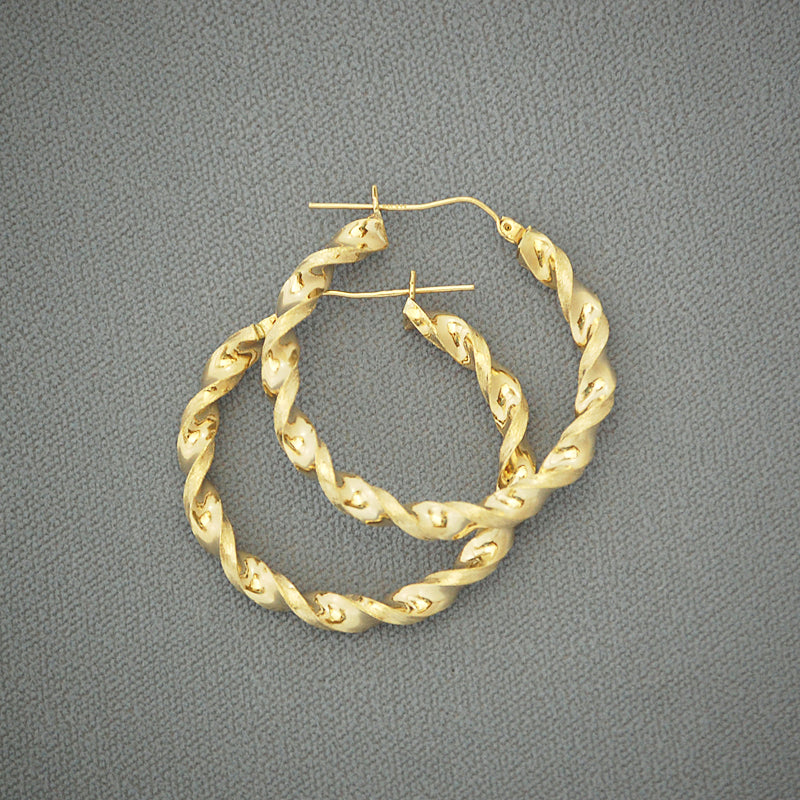 Close-up view of 10K yellow gold 4mm twisted hoop earring texture and shine