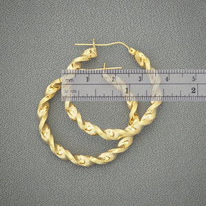 Close-up detail of 4mm twisted texture and hinged snap closure on 10k gold hoop earrings