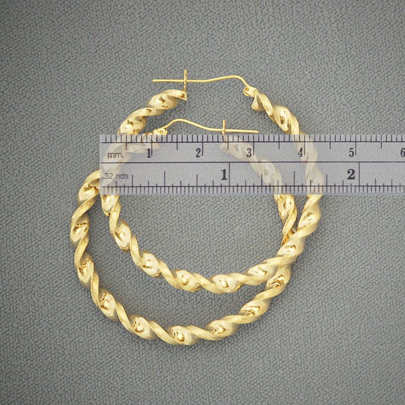Close-up detail of 4mm hollow 10K gold twisted hoop earrings showing texture and clasp