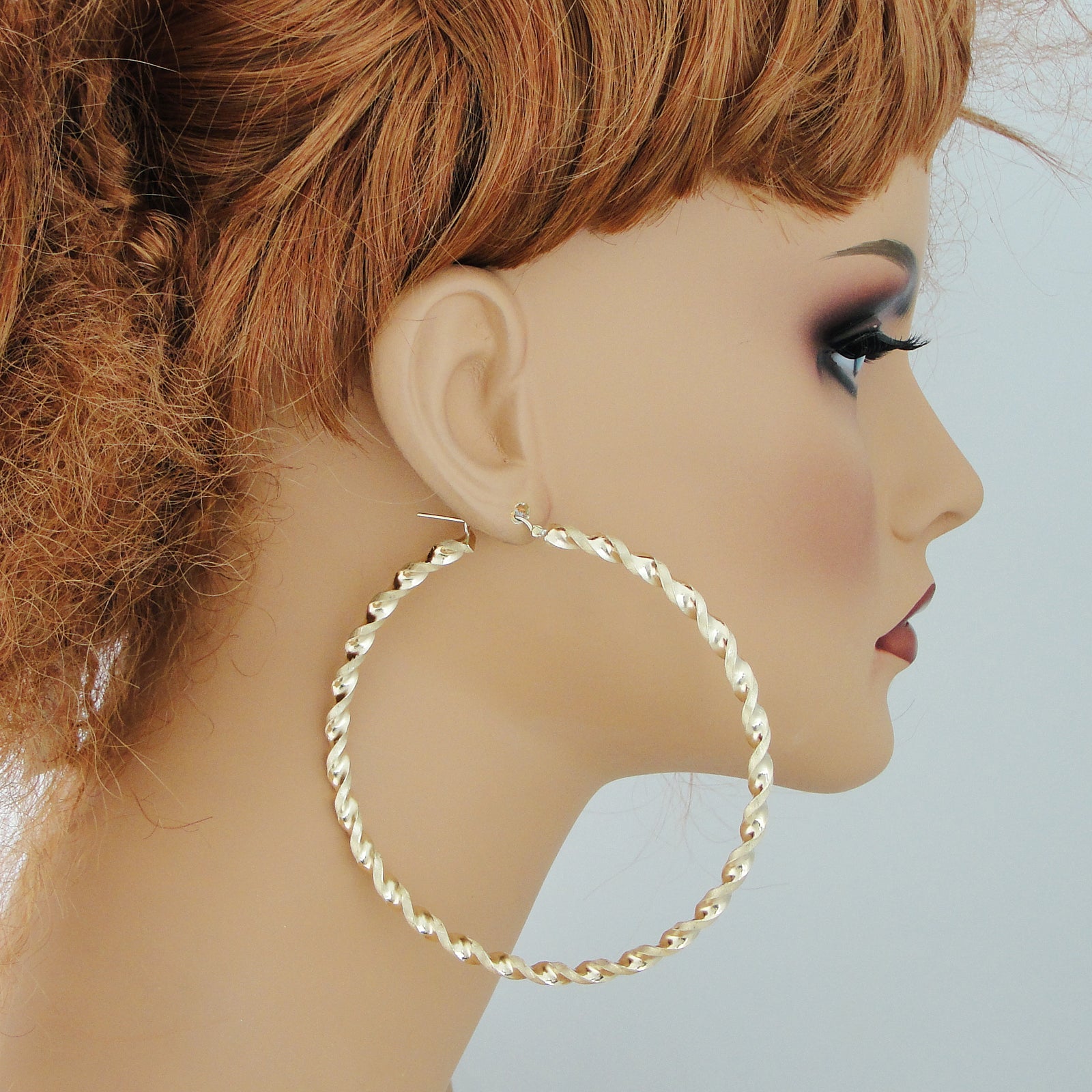 Model wearing 3.5 inch extra large 10k gold twisted hoop earrings showing size and fit