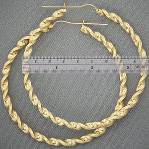 Close-up view of 4mm twisted design and secure hinged latch-back closure on 10k gold hoop earring