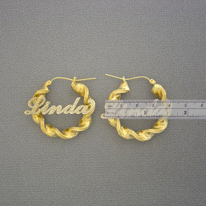 Pair of custom two-tone 10k gold 6mm twisted hoop nameplate earrings with hinged snap closure.