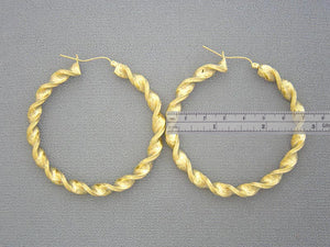 Large 2.75-inch 10K yellow gold twisted hoop earrings shown for size reference