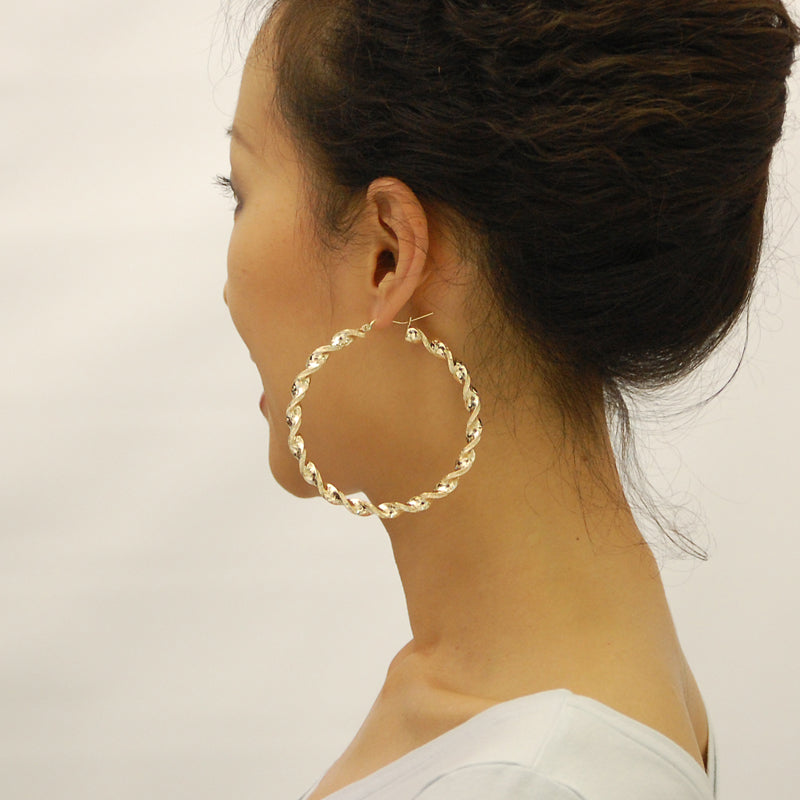 Model wearing 3-inch 10K yellow gold 6mm twisted hoop earrings